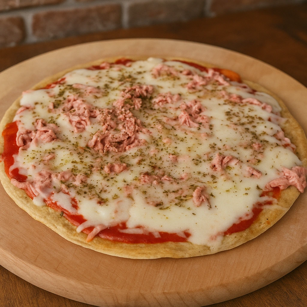 Cijela zdrava dijetalna pizza bez brašna s topljenim sirom, paradajz sosom i purećom salamom, fotografirana u toplom prirodnom svjetlu na drvenoj podlozi.