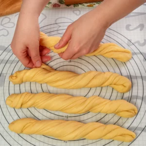 Uvijanje dugih traka tijesta u spiralni oblik prije slaganja u kalup