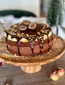 Slojevita čokoladna torta prelivena ganacheom i posuta sjeckanim pistacijama