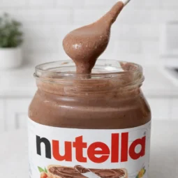 Domaca nutella u staklenci s kremastim čokoladno-lješnjak namazom i žlicom iznad