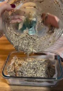 Ulijevanje smjese s makom i naribanim jabukama u staklenu posudu za pečenje