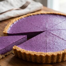 Raw torta od borovnica narezana na kriške na drvenoj dasci