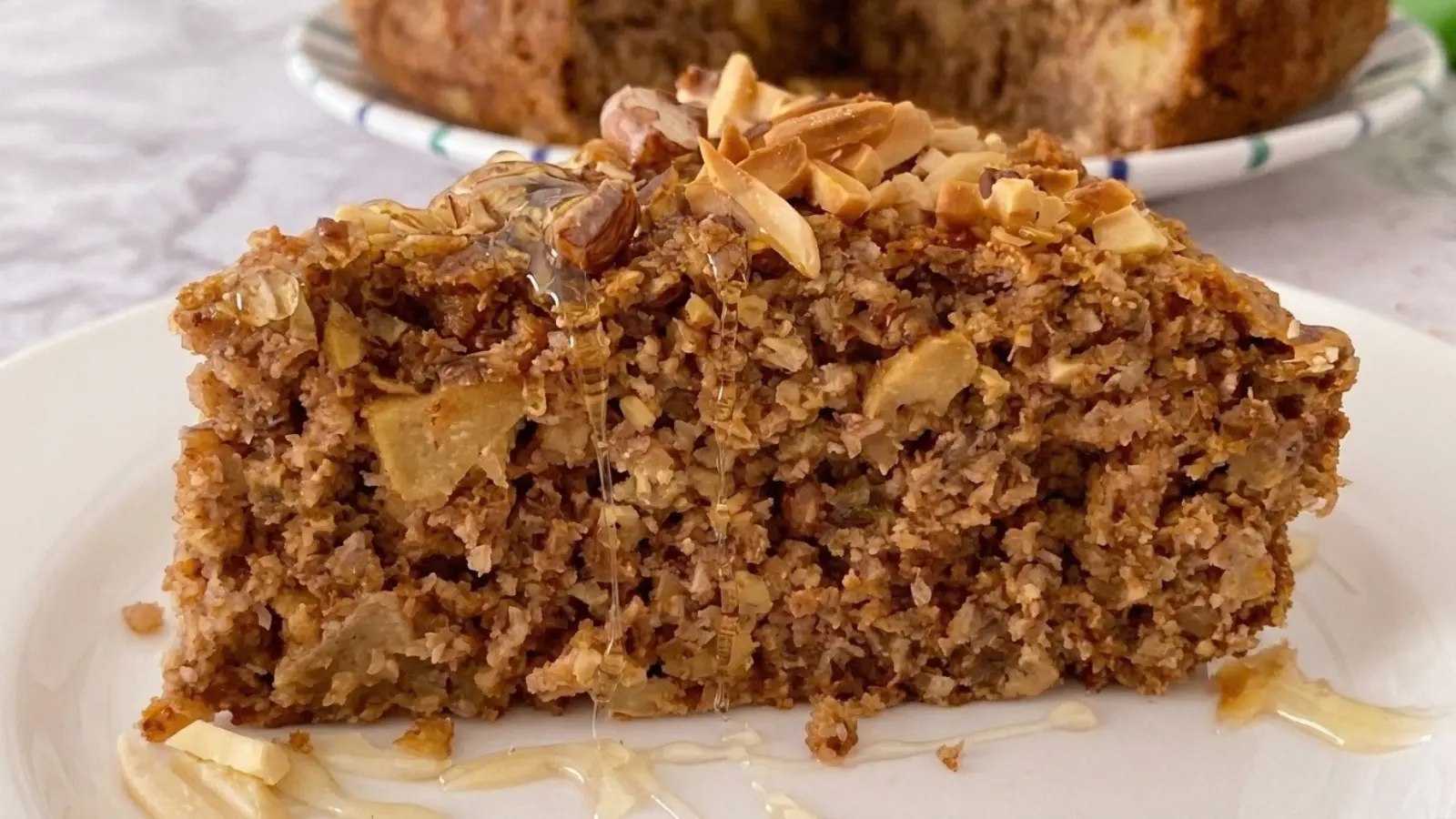 Fit kolač s jabukama, presjek kriške s medom i prženim bademima