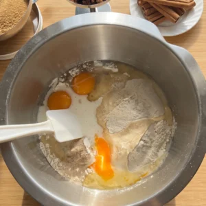 Jaja, mlijeko, brašno i suhi kvasac u posudi miksera prije miješanja tijesta